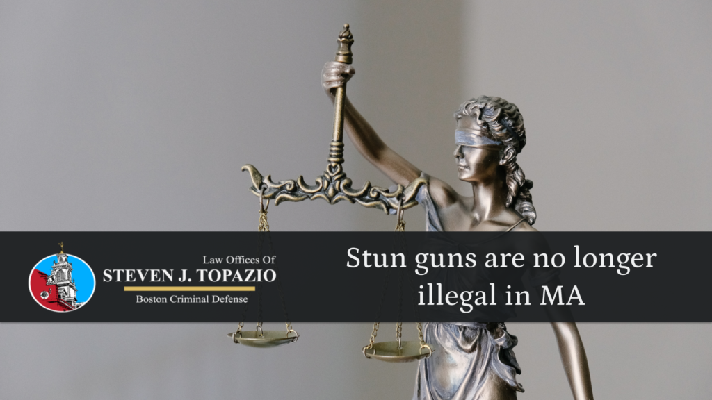 Attorney Steven J. Topazio logo with the blog title 'stun guns are no longer illegal in Massachusetts's' laid overtop of the scales of justice.